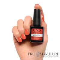 Manucure corail orangé lumineux réalisée avec CND Shellac B-Day Candle 12,5 ml, flacon présenté en main